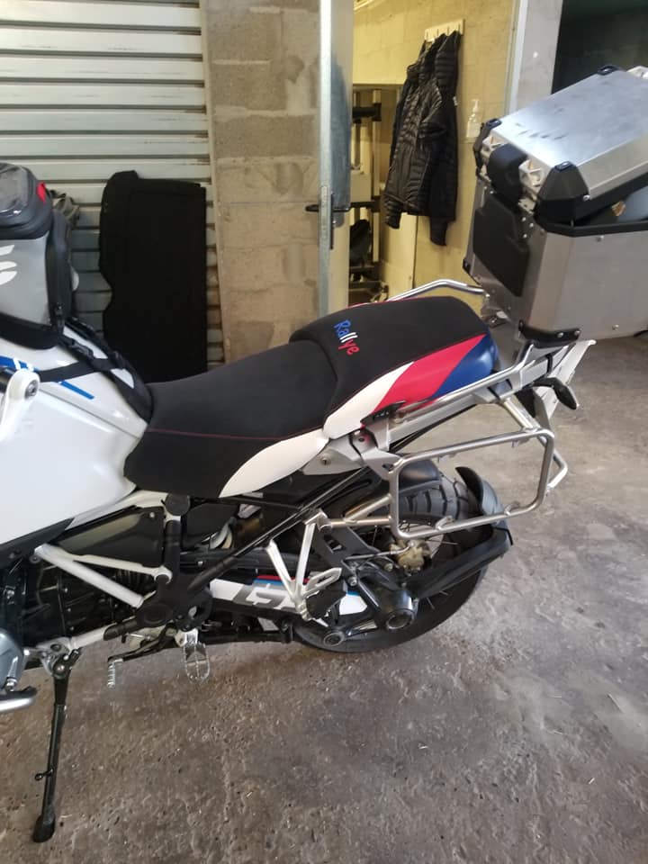 Moto BMW GS avec selle Rallye tricolore, supports de valises et top case en aluminium dans un garage.